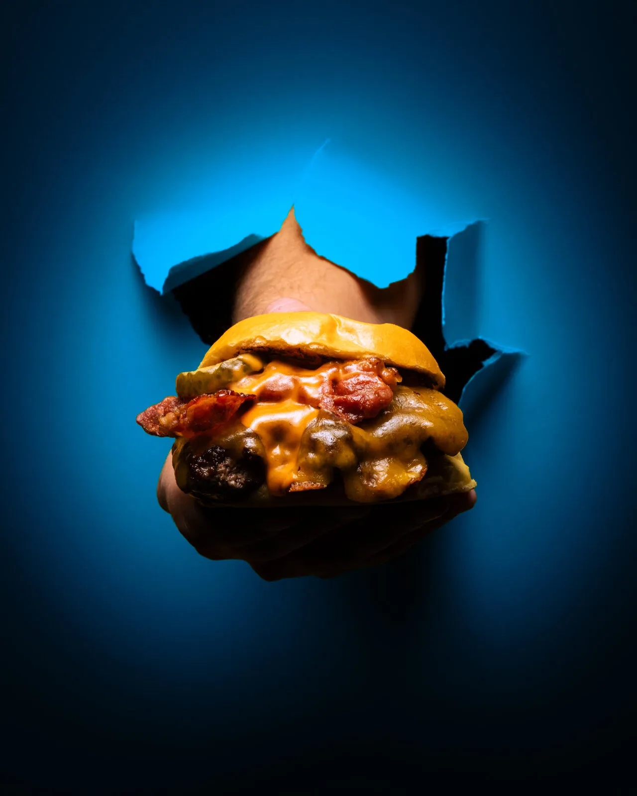 Hamburguesa atravesando un papel azul