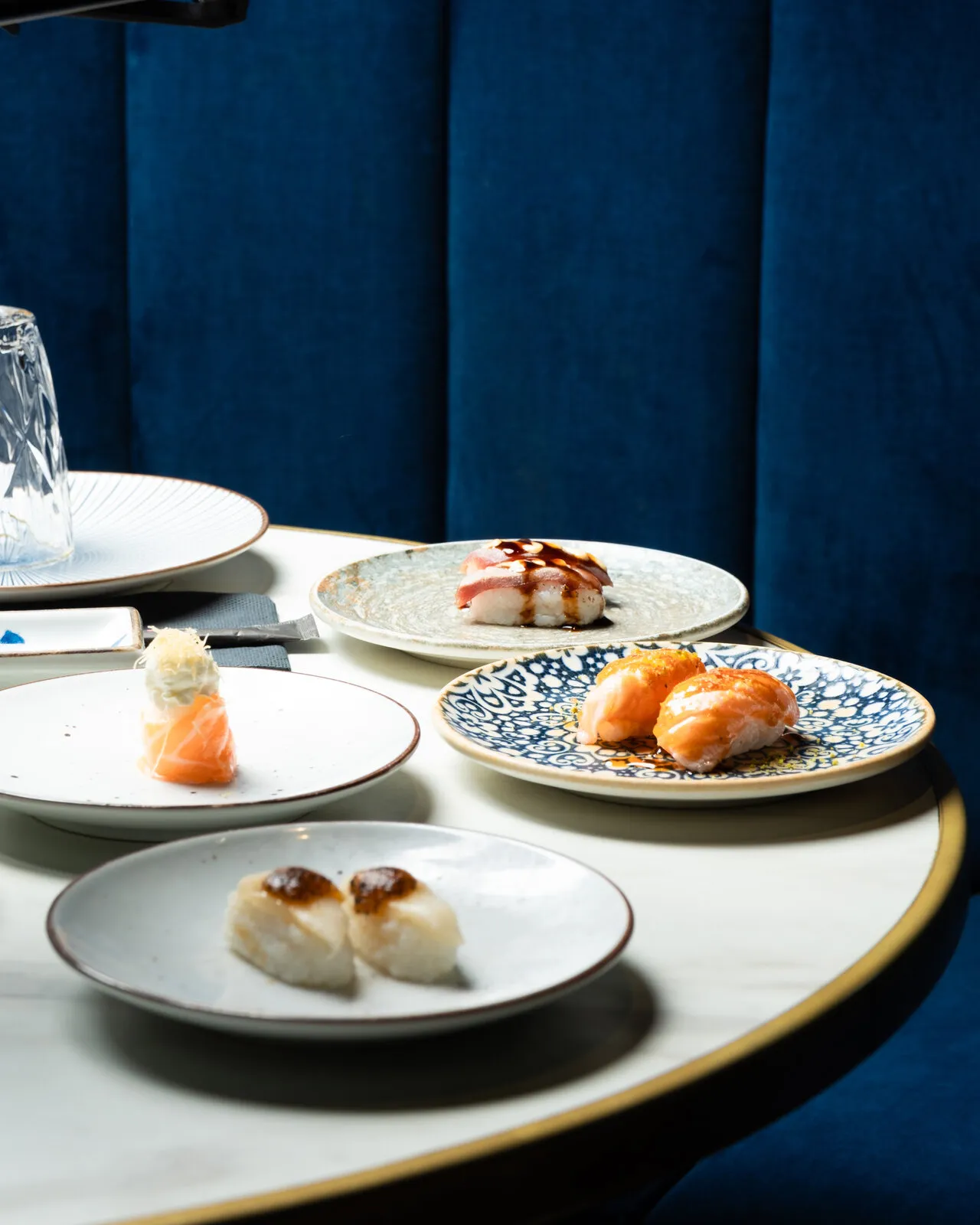 Mesa redonda con sushi en un sofá azul